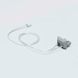 A transparent cable links a small, rectangular gray Cut & Connect End Cap for Roma Profile to a linear lighting system, both placed on a light gray surface.