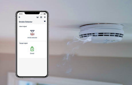 A smartphone shows a fire alarm alert from the 2-Channel Smart Wi-Fi Input Status Module ~ inputSensorD by Blebox, demonstrating real-time sensor monitoring and instant home automation notifications during smoke detection.