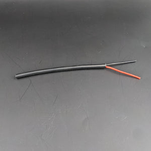 A 2-Core 18 AWG Silicone Sheathed Wire for Single Color LED Strip and Power, featuring a short black flexible cable with stripped ends showing red and black inner wires, is displayed on a plain dark background.