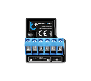 The shutterBoxDC by Blebox is a black and blue wireless controller for DC roller blinds/shutters (12-24V DC, 5A max), featuring six terminal slots and remote smart control. Product name is labeled as Smart Wireless Roller Blind/Shutter Controller.