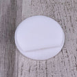 A round, flat Plastic End Cap for Cascade38 Profile with a shallow groove rests on a textured, light-colored wooden surface.