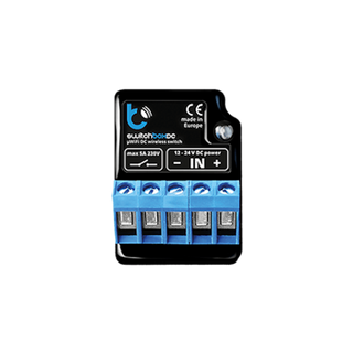 The switchBoxDC by Blebox is a compact black and blue wireless on/off power switch controller with four blue terminal blocks, input/output markings, CE certification, and is labeled “made in Europe.”.