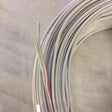 A coiled bundle of 2-Core 18 AWG PVC Flat Ribbon Wire for Single Color LED Strip and Power lies on a light surface, showing two ends—one with a red stripe, one all white—perfect for LED installation projects.